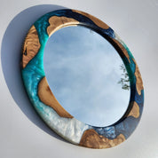 Ocean-inspired epoxy and olive wood wall art mirror featuring a natural wood frame and ocean blue epoxy accents.