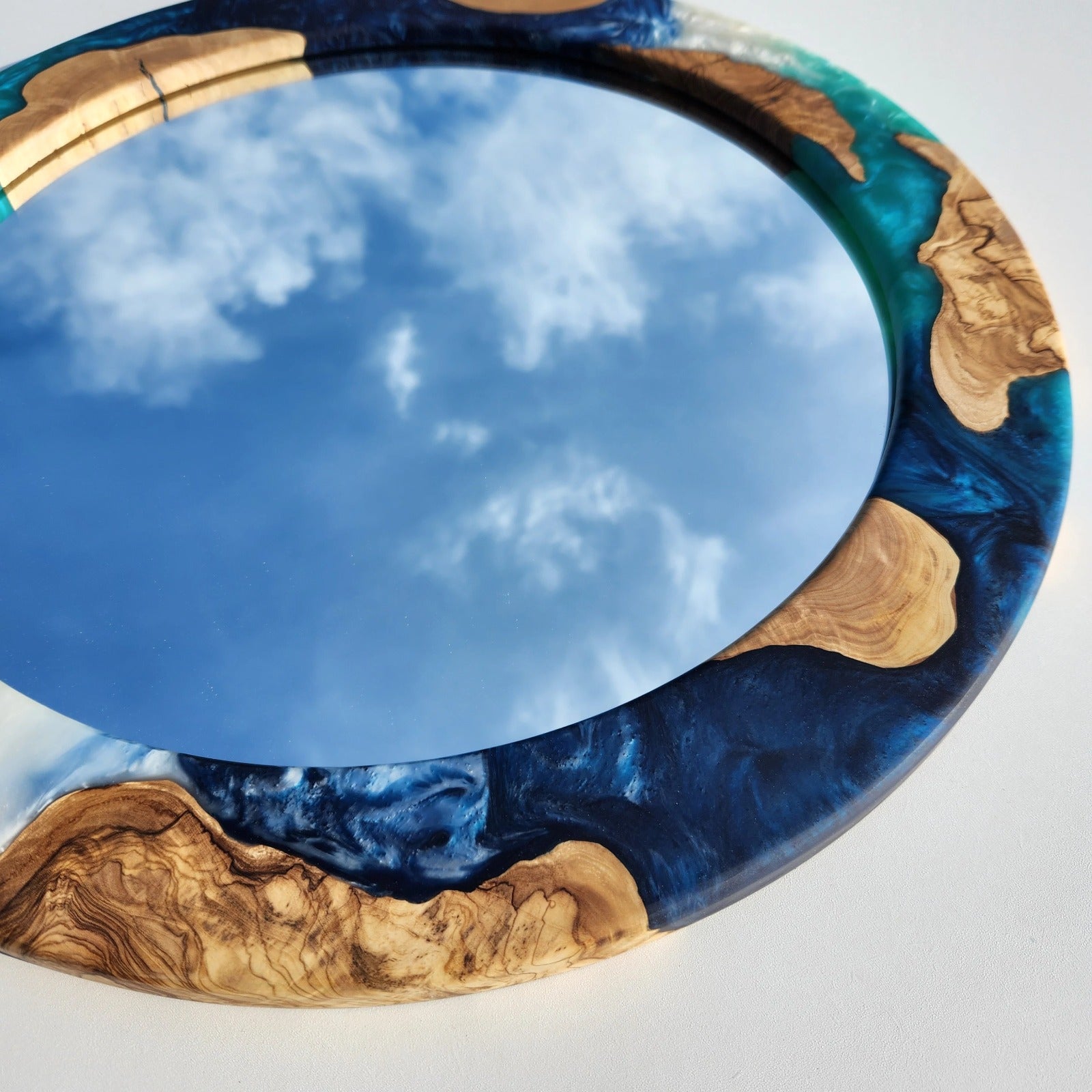 Ocean-inspired epoxy and olive wood wall art mirror by Artdesigna featuring a handcrafted wood frame with ocean blue epoxy accents.