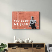 Banksy - You Loot We Shoot | Designer's Collection Glass Wall Art - Artdesigna