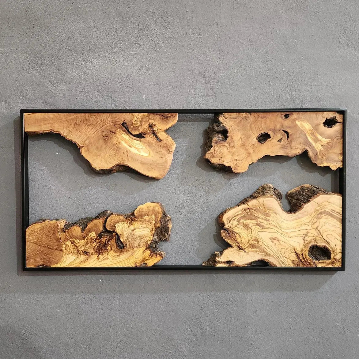 Wooden art piece with natural patterns on a gray wall